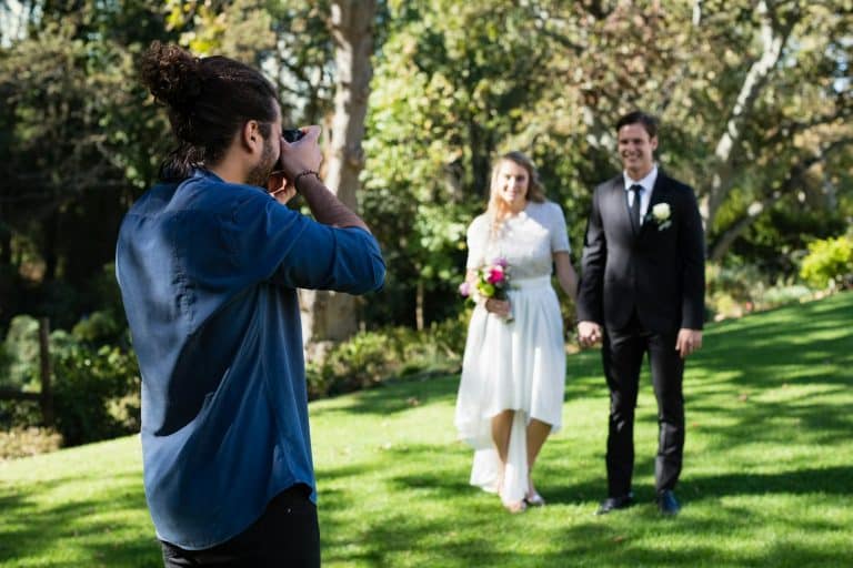 Photographer taking photo of newly married couple
