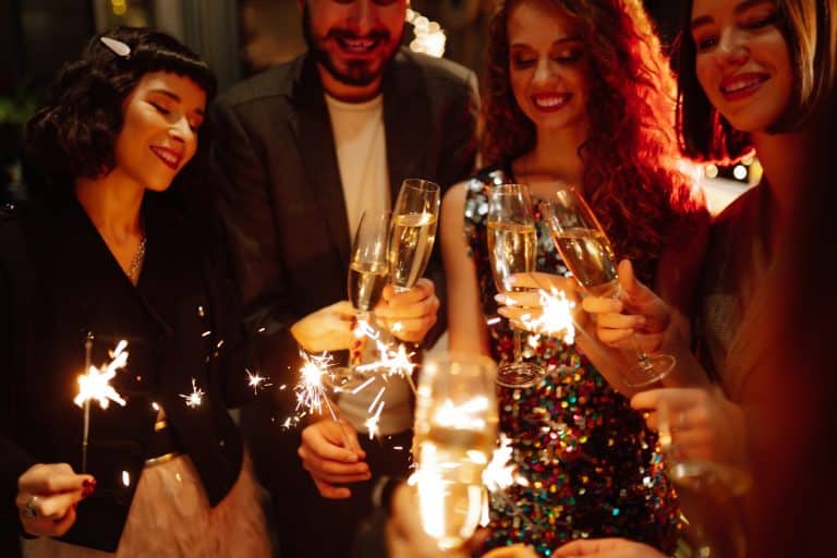 Sparkling sparklers in hands. Playing firework to celebrate winter holidays with friends at party