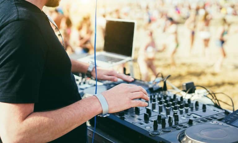 Dj mixing music at beach party during summer event