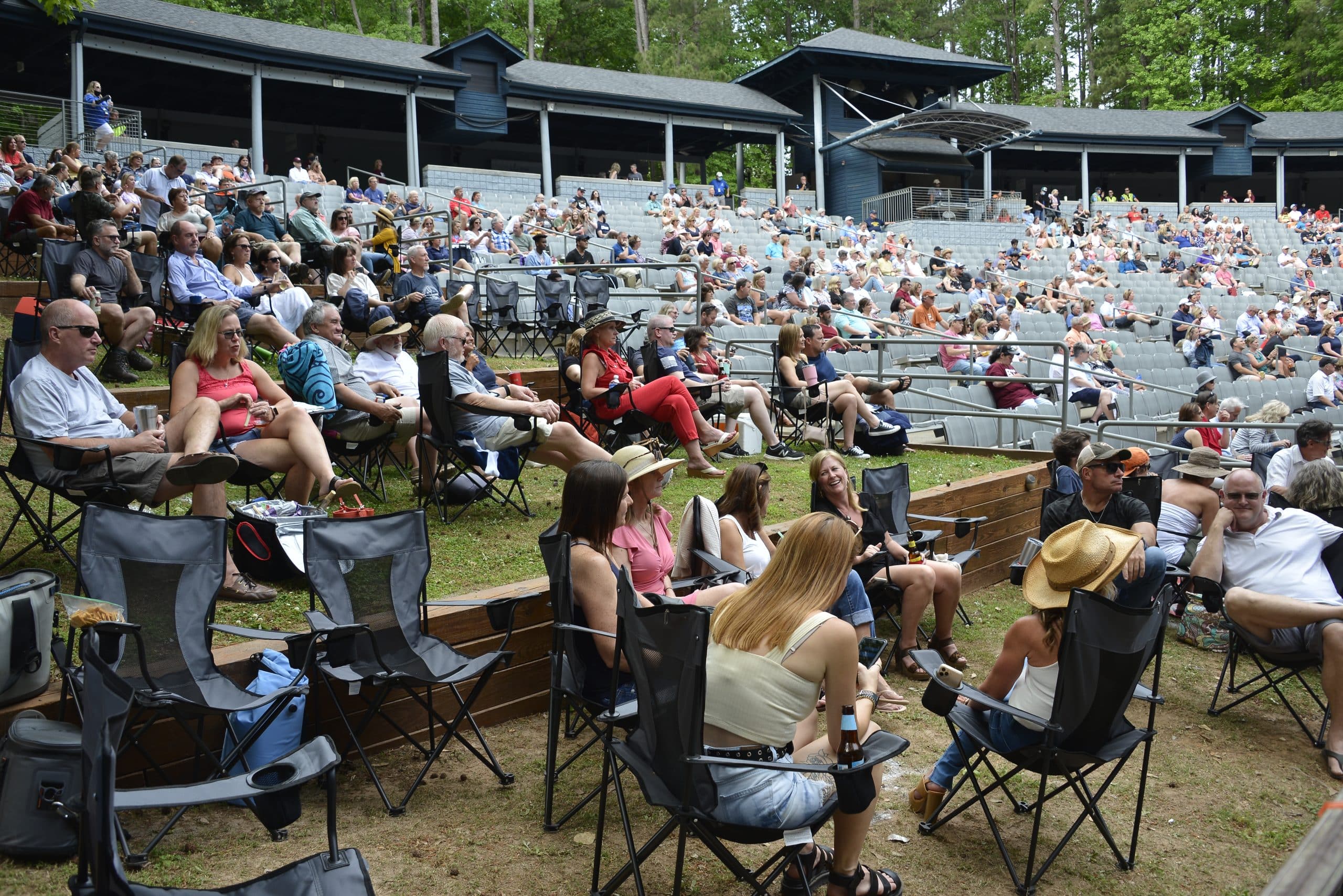 Audience seated throughout an outdoor amphitheater at the Bridging the Gap benefit concert.